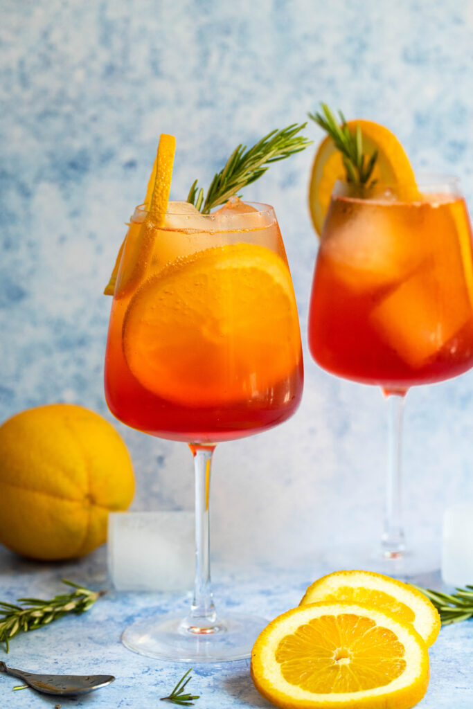 Aperol Spritz with homemade rosemary simple syrup, sliced naval oranges, Prosecco, club soda and more!