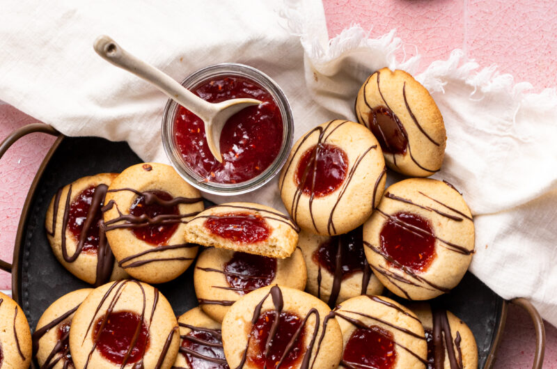 If you're looking for a paleo dessert that is easy to make and delicious, this cookie recipe is for you! These Paleo Thumbprint Cookies with homemade raspberry jam and a dark chocolate drizzle are the perfect sweet treat.