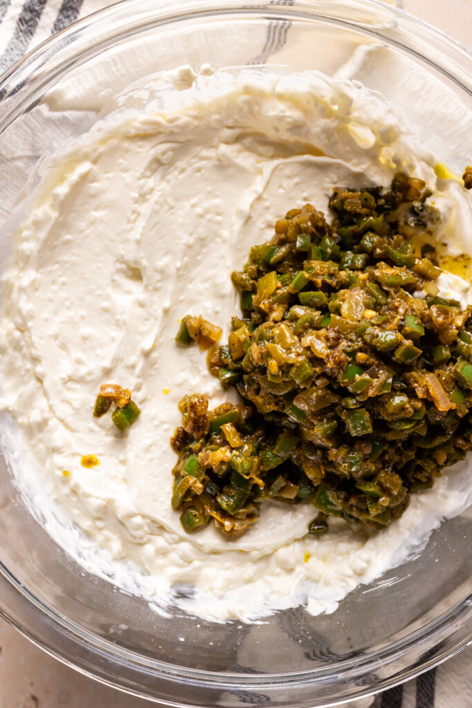 Adding your sautéed mix into the greek yogurt and cream cheese mixture.