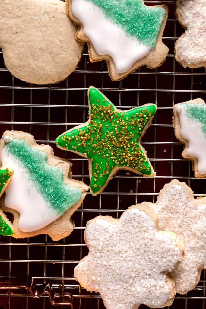 gluten-free sugar cookies in the shape of a Christmas tree, star, and snowflake decorated with icing and sprinkles