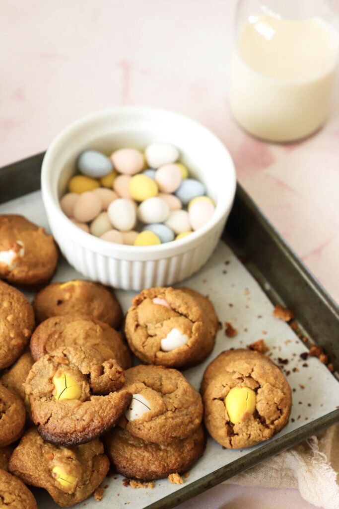 This image is focused on the peanut butter cookies. The small bowl filled with the gluten-free mini chocolate eggs is slightly out of focus.