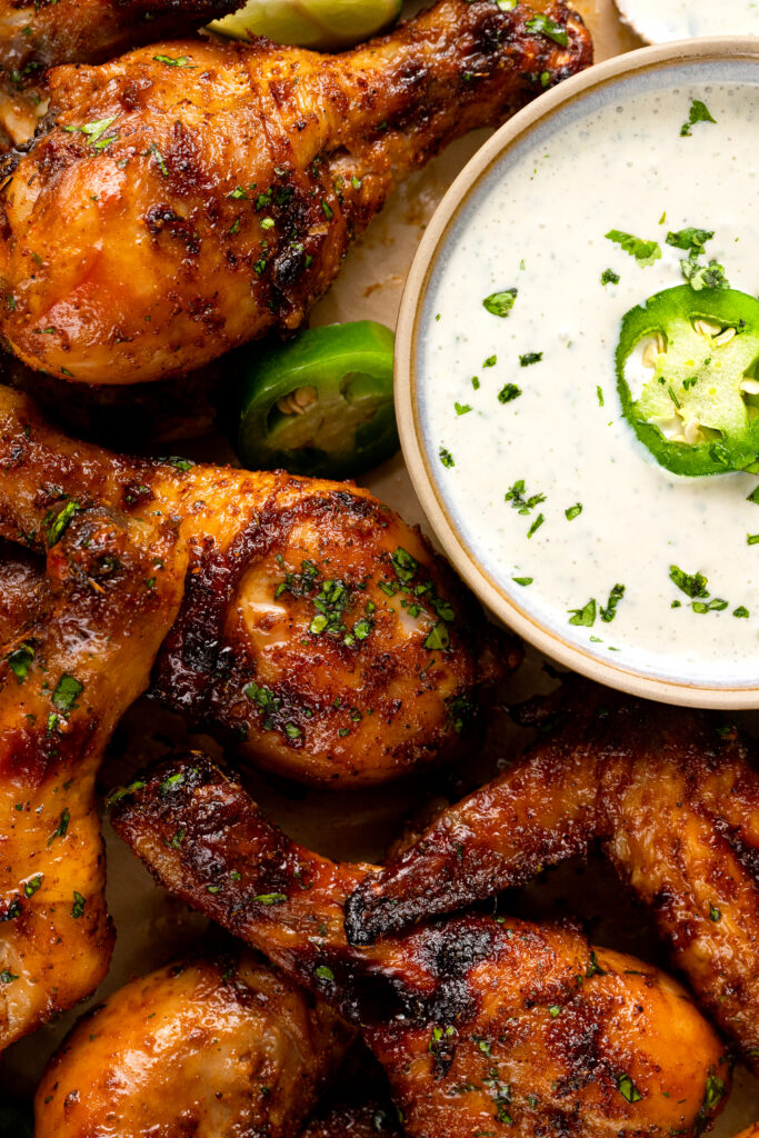 A close up photo of the cilantro lime baked chicken with a side of the jalapeño ranch dip.